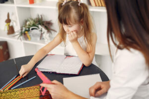 Criança estudando com ajuda de um adulto