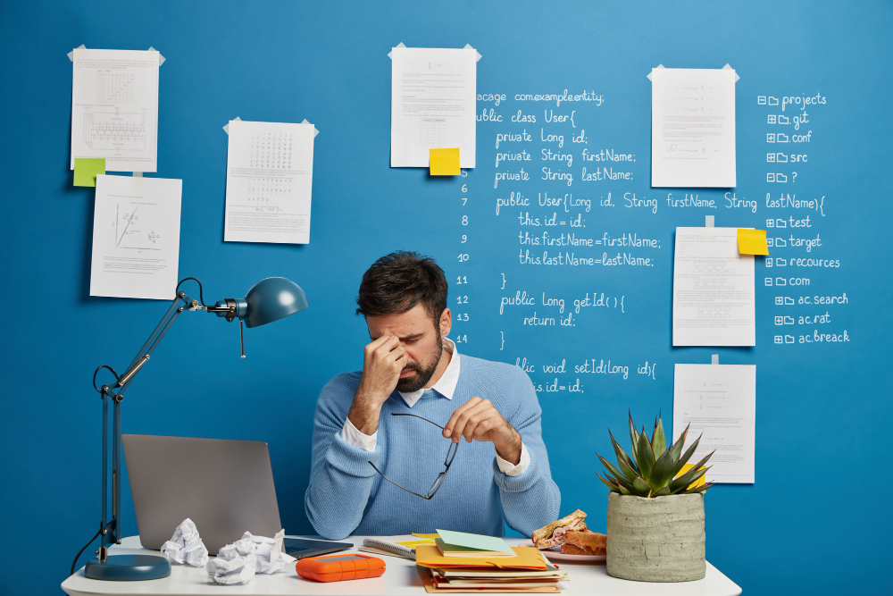 Homem na mesa de trabalho cheio de atividades para fazer