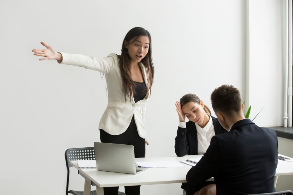 Mulher discutindo com outro homem em uma sala de reunião